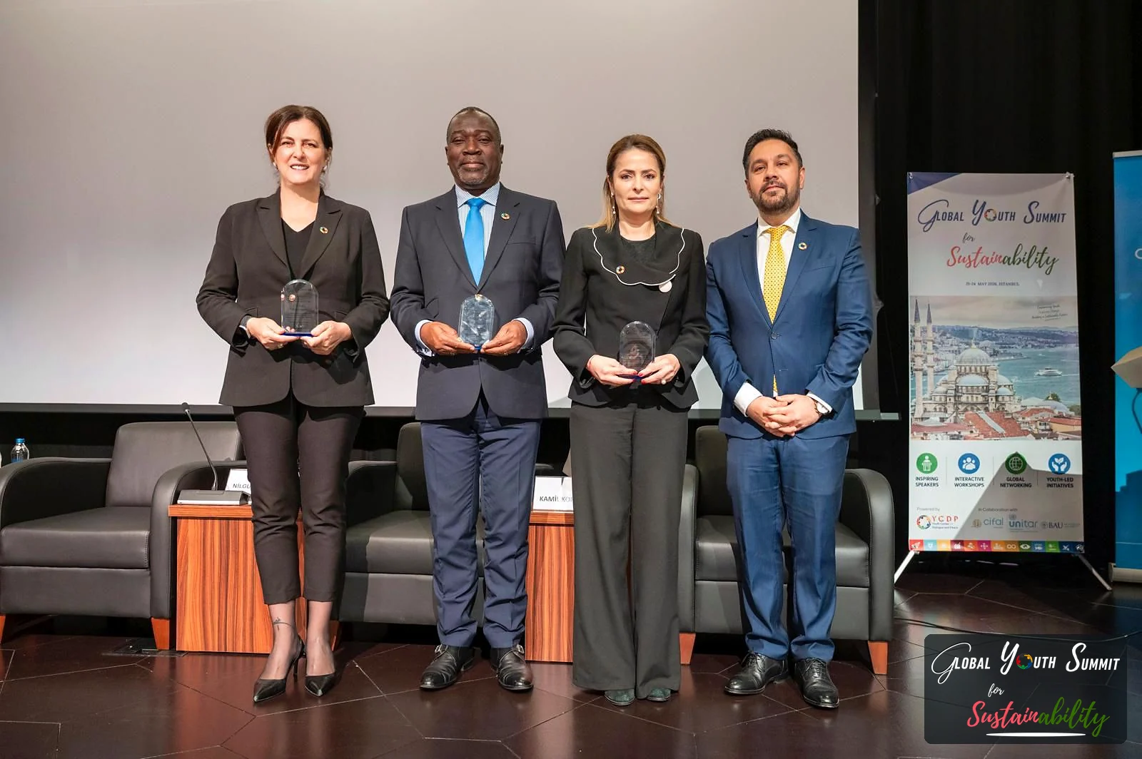 Opening ceremony speakers holding commemorative awards