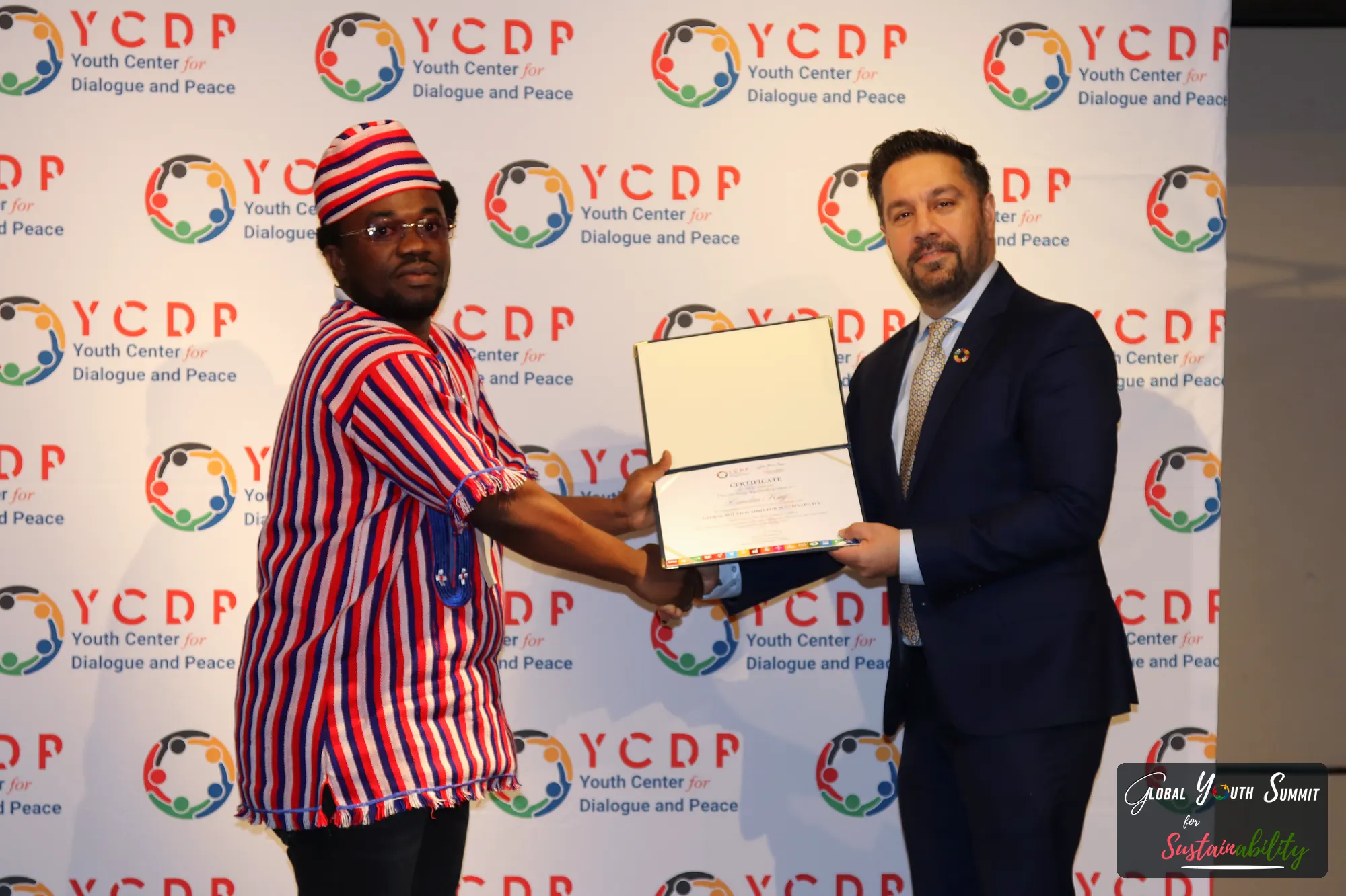 A delegate receiving a framed certificate at the YCDP backdrop