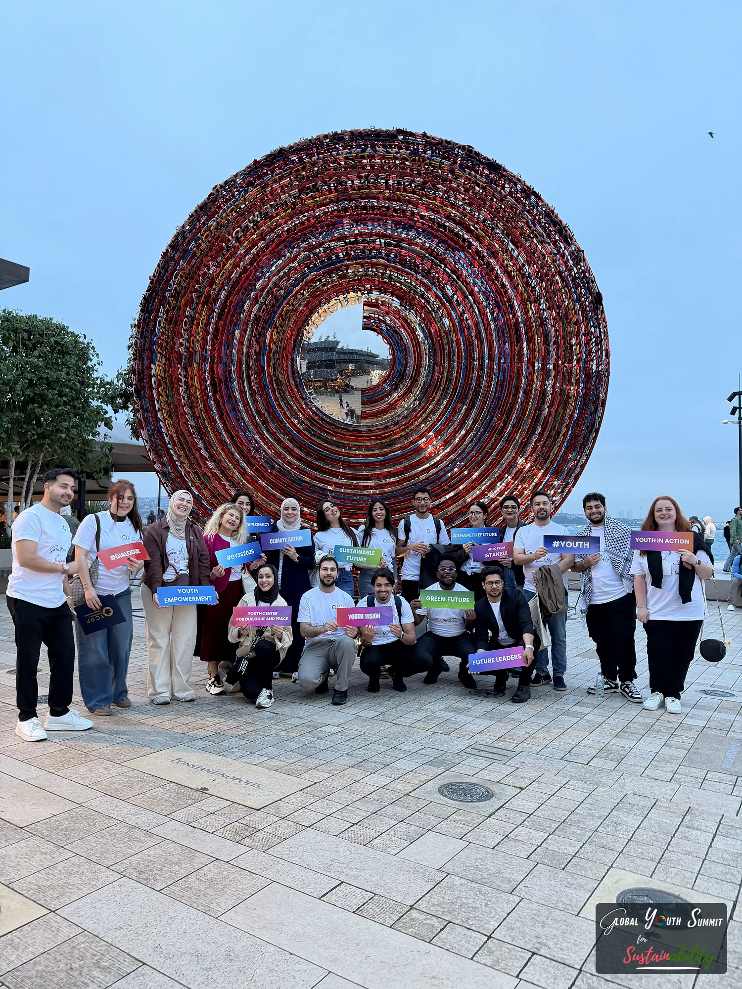 Delegates posing with sustainability signs at The City of Names