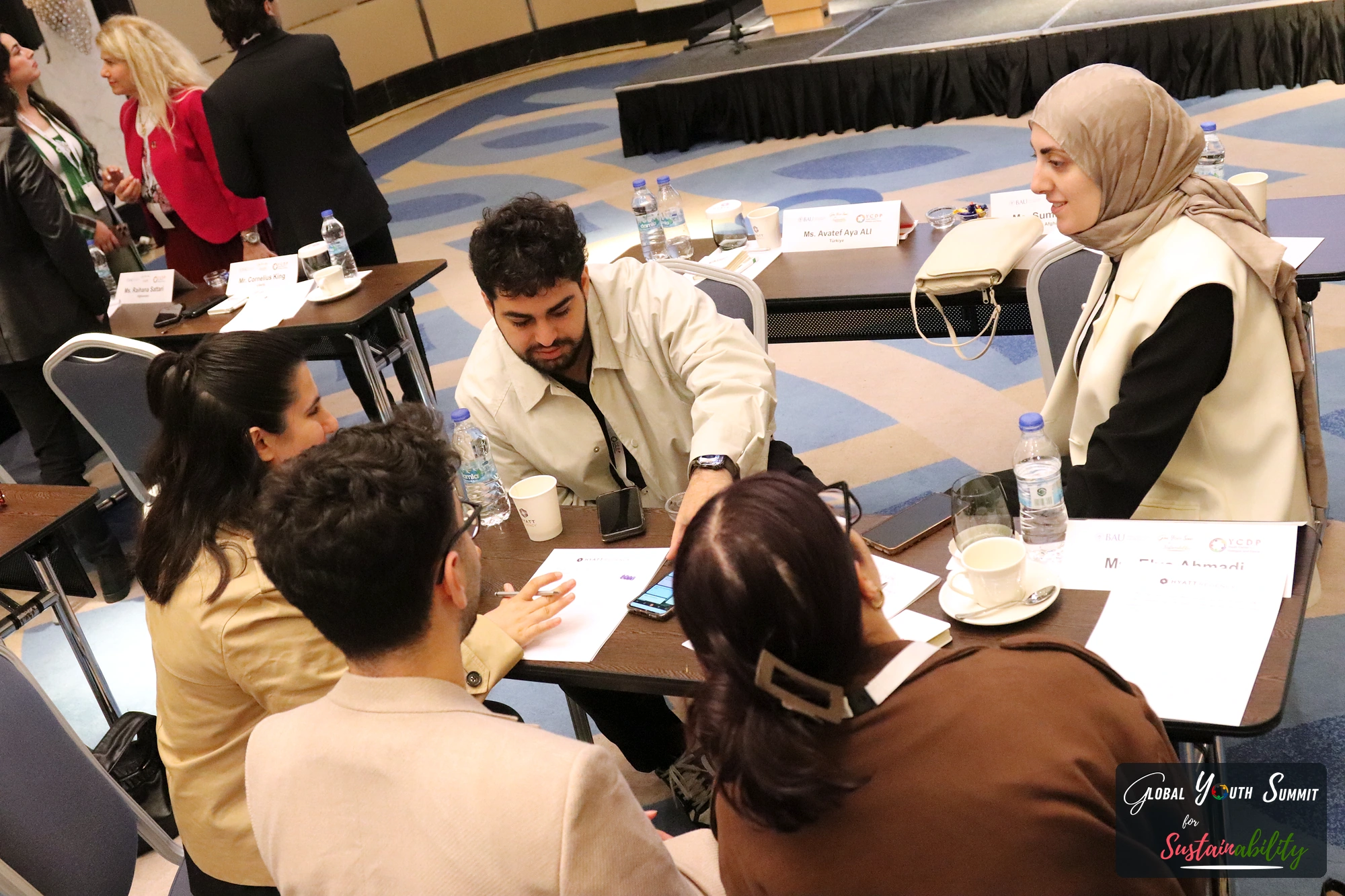 Delegates in a group discussion around a table